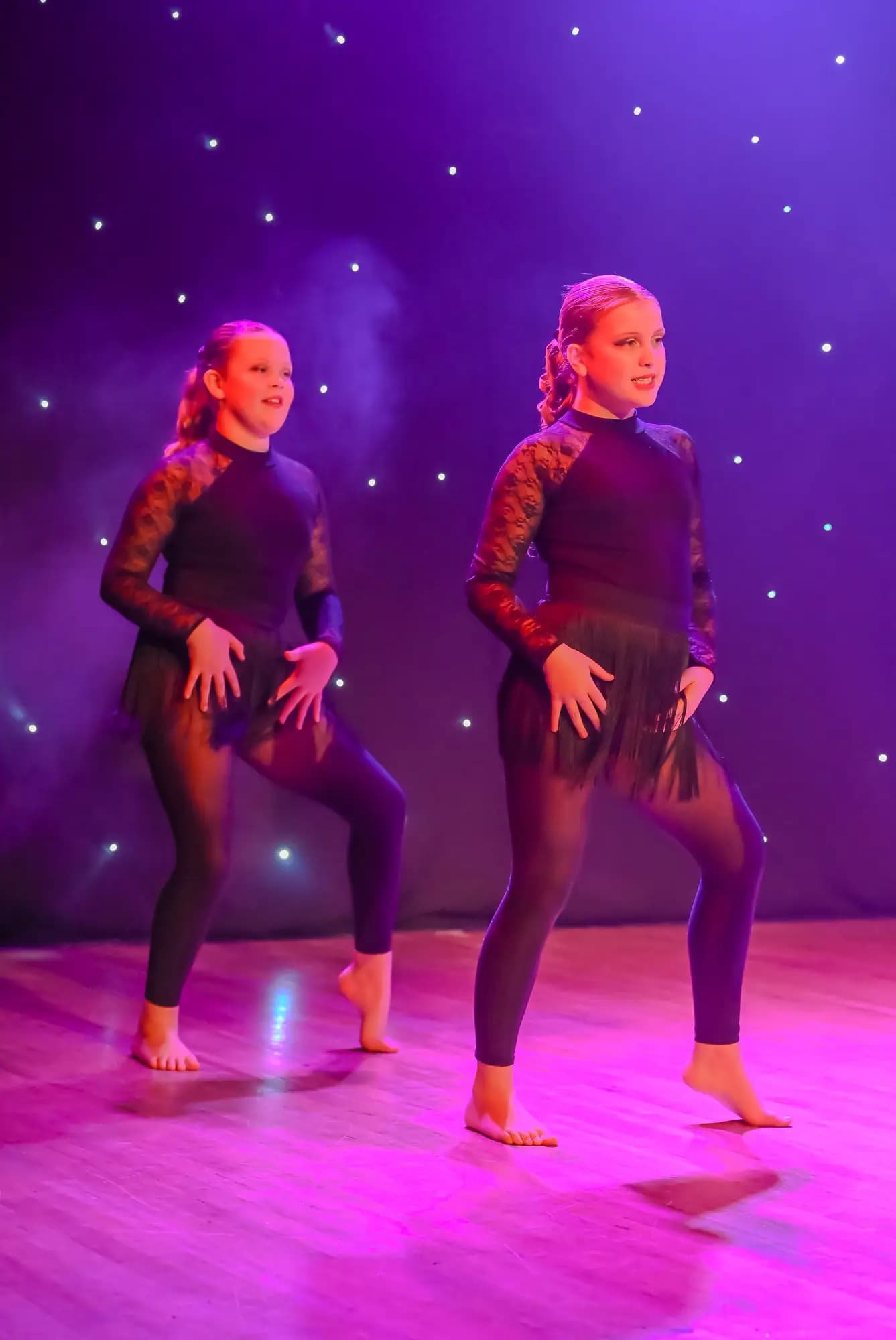 Two dancers performing a synchronised routine on stage
