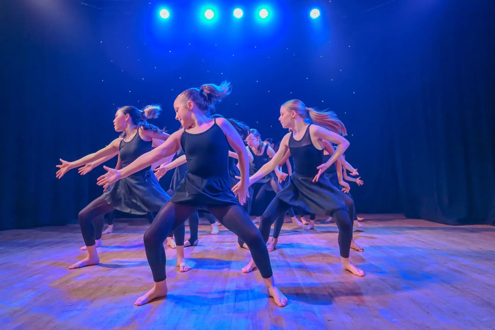 Dancers in a powerful wide-stance group pose