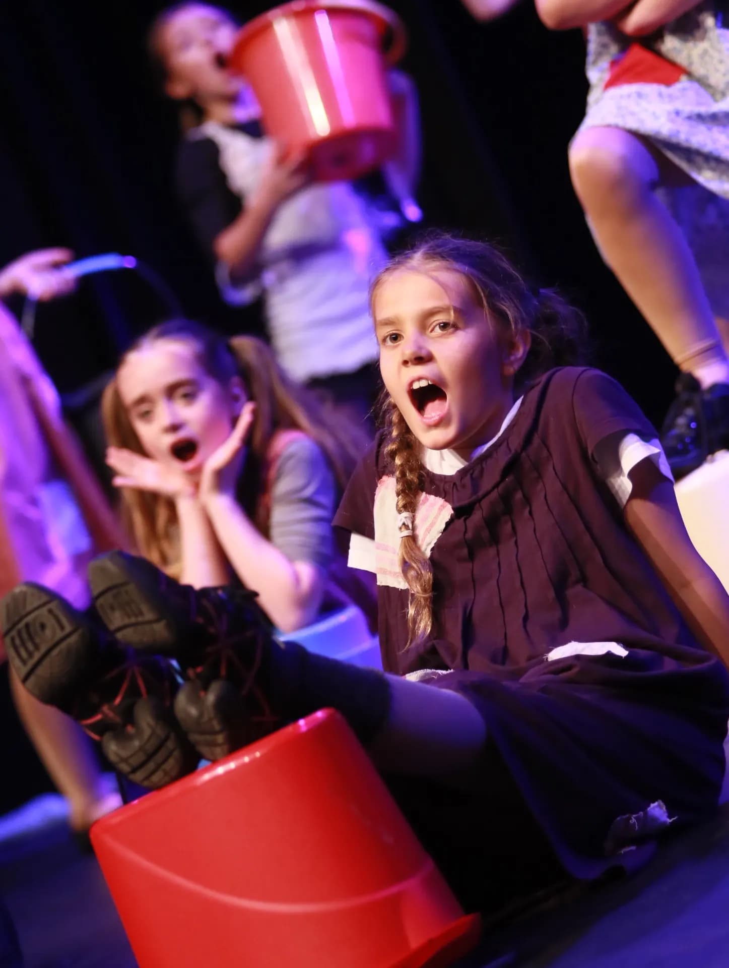 Young performers in an Annie orphans scene with buckets