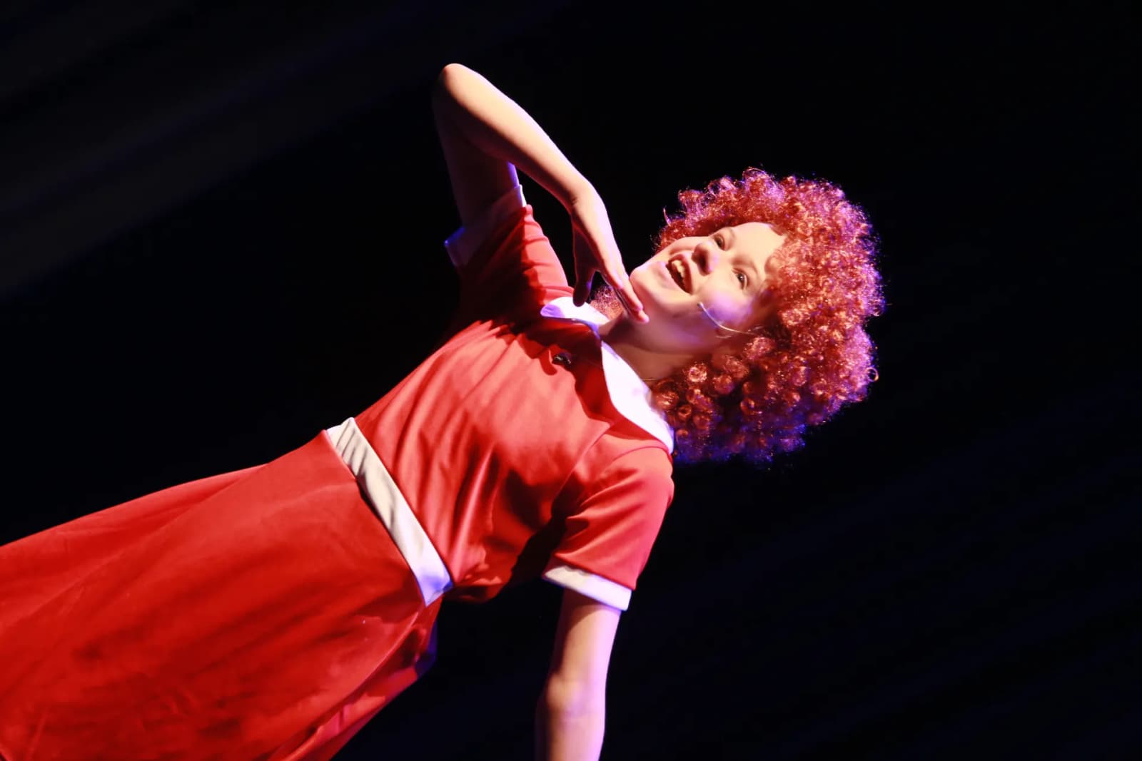 Soloist in a red Annie costume mid-performance